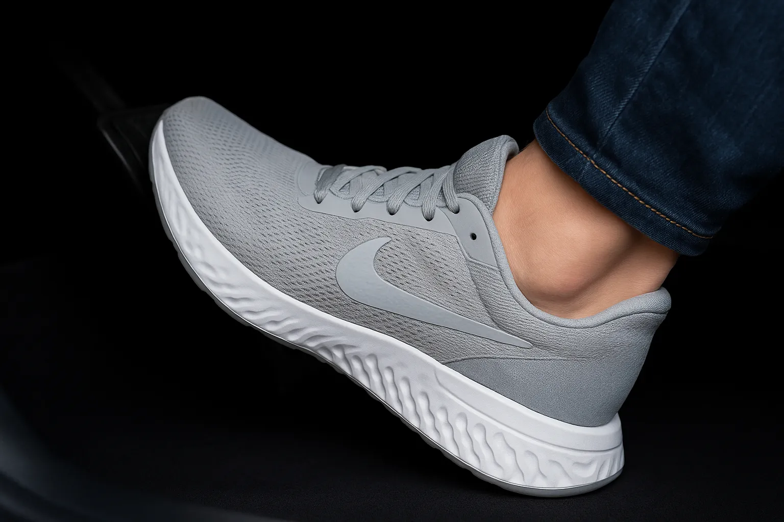 پای راننده روی پدال خودرو با کتونی ورزشی مناسب رانندگی در نور طبیعی و فضای واقعی.